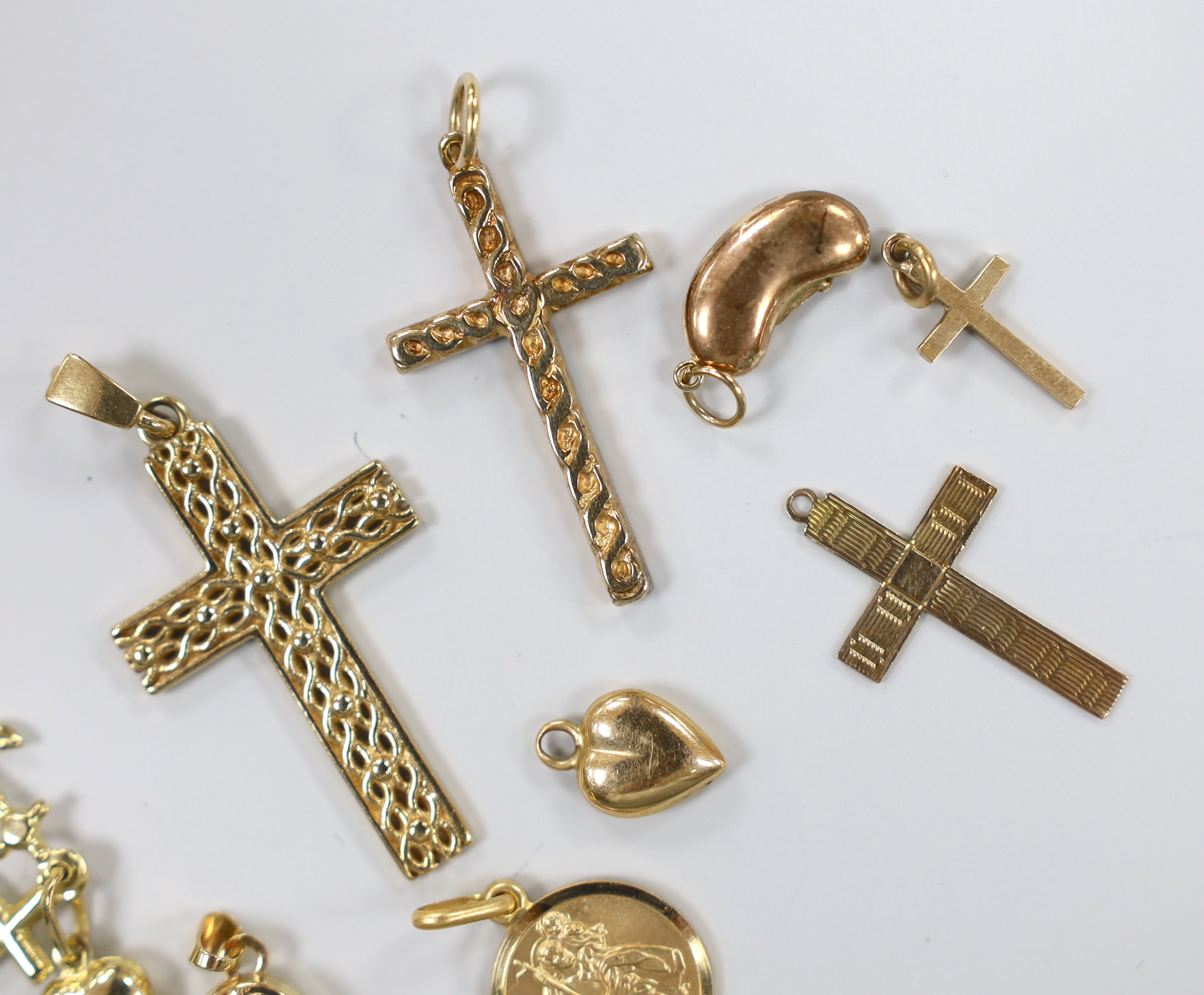 Three modern 9ct gold cross pendants, largest 34mm, a 9ct gold bean charm and St. Christopher pendant, a similar 375 pendant, cross pendant, locket and triple charm and two yellow metal items, gross weight 13.3 grams.